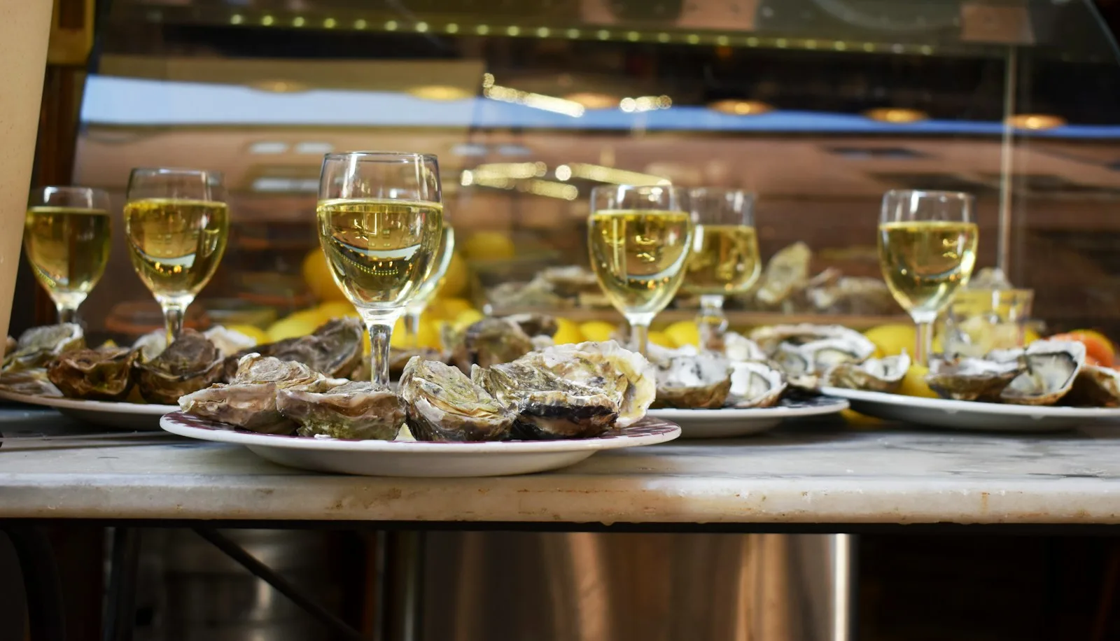 Plateau d'huîtres et verres de vin blanc sur la table d'un café en terrasse